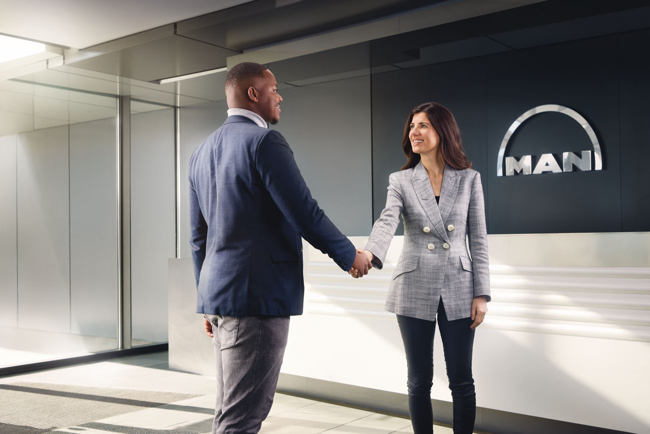 Business partners shaking hands in MAN reception area